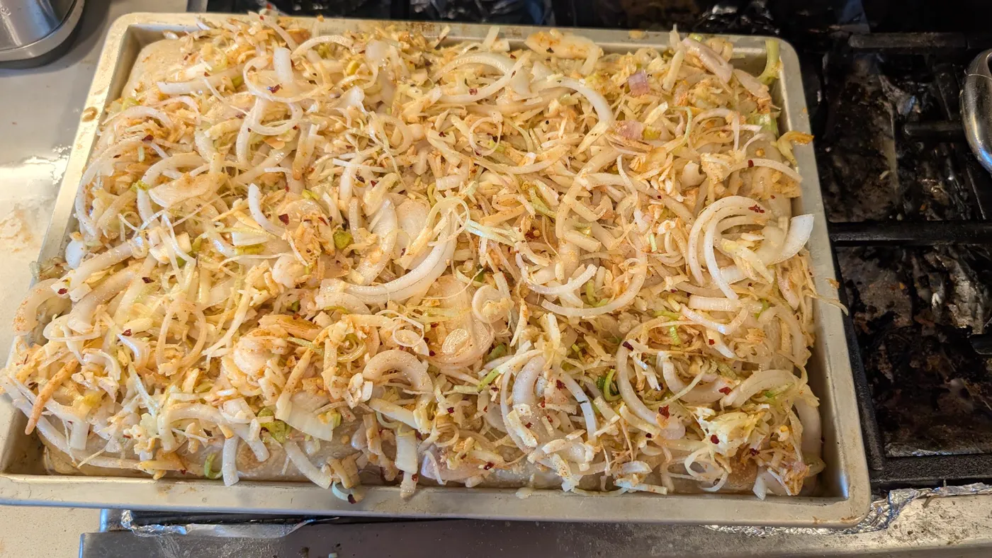 Focaccia dough covered in sliced onions and cheese